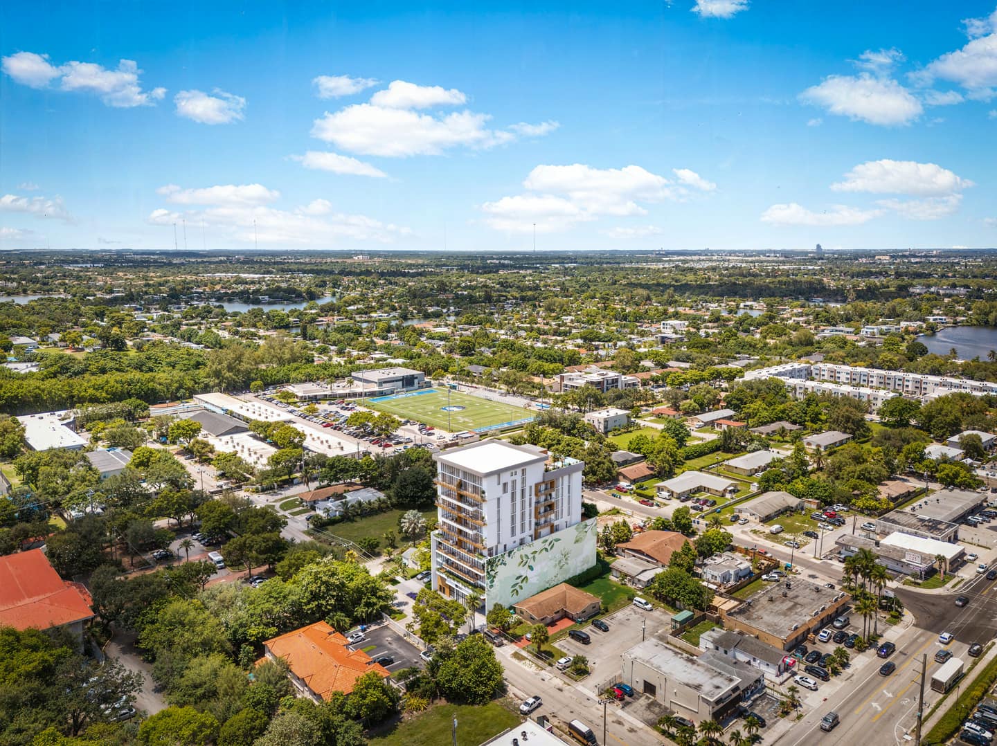 Renderizado aéreo noroeste de Eden Residences mostrando el edificio boutique de 10 pisos en su cuadra de Ojus