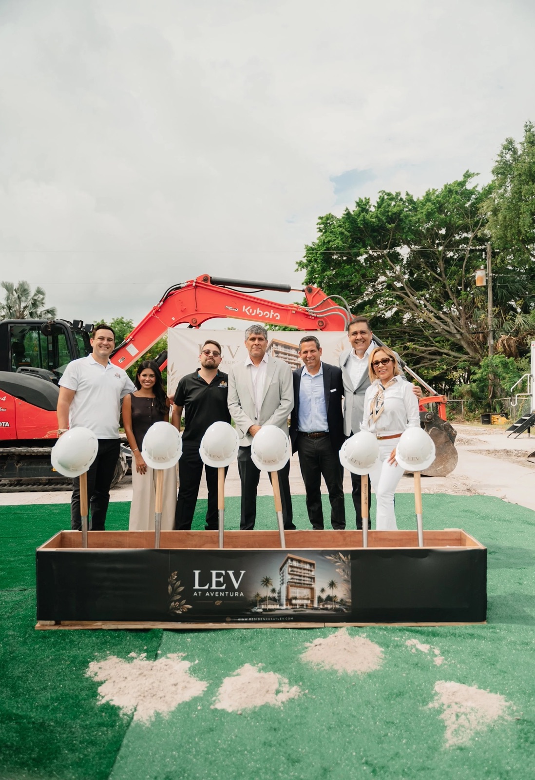 Equipe da Growin Group no início das obras de junho de 2026 do LEV at Aventura, com o render do projeto na caixa cerimonial de areia