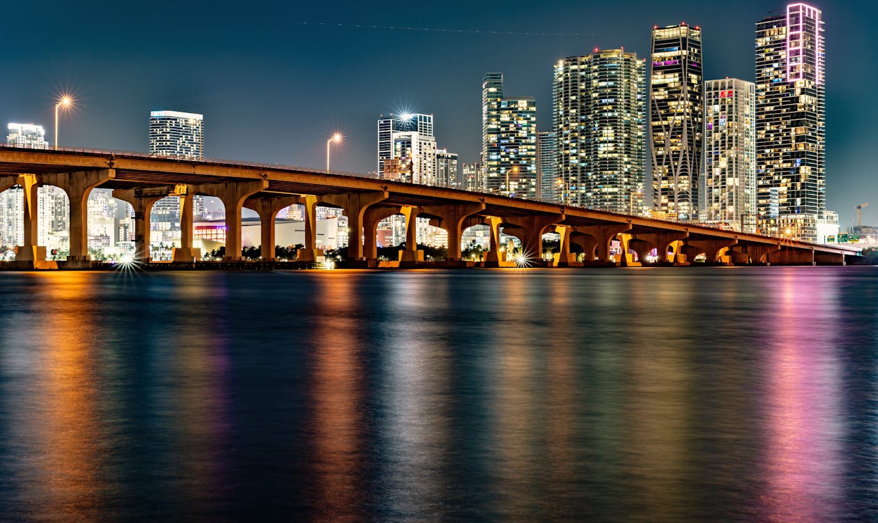 Horizonte de Miami iluminado à noite sobre a Baía de Biscayne, refletindo a identidade de vida noturna por trás das residências de marca de música