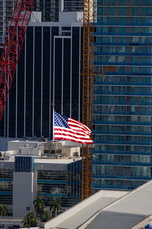 A construction crane rising beside Miami high-rise towers, the redevelopment that follows a condo buyout and demolition
