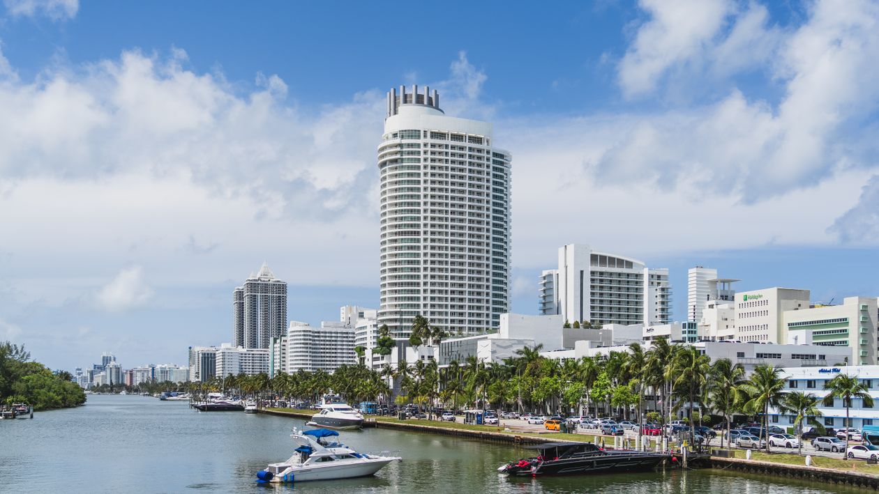 Orla de Miami Beach com uma torre de condomínios em destaque, marina e barcos na Flórida