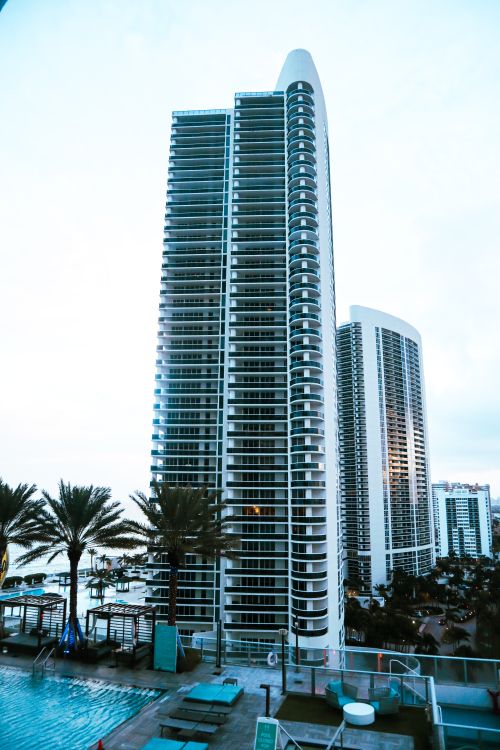 Torre de condomínio à beira-mar em Sunny Isles com deck de piscina, onde as apólices mestras costeiras veem o maior alívio de seguro de 2026