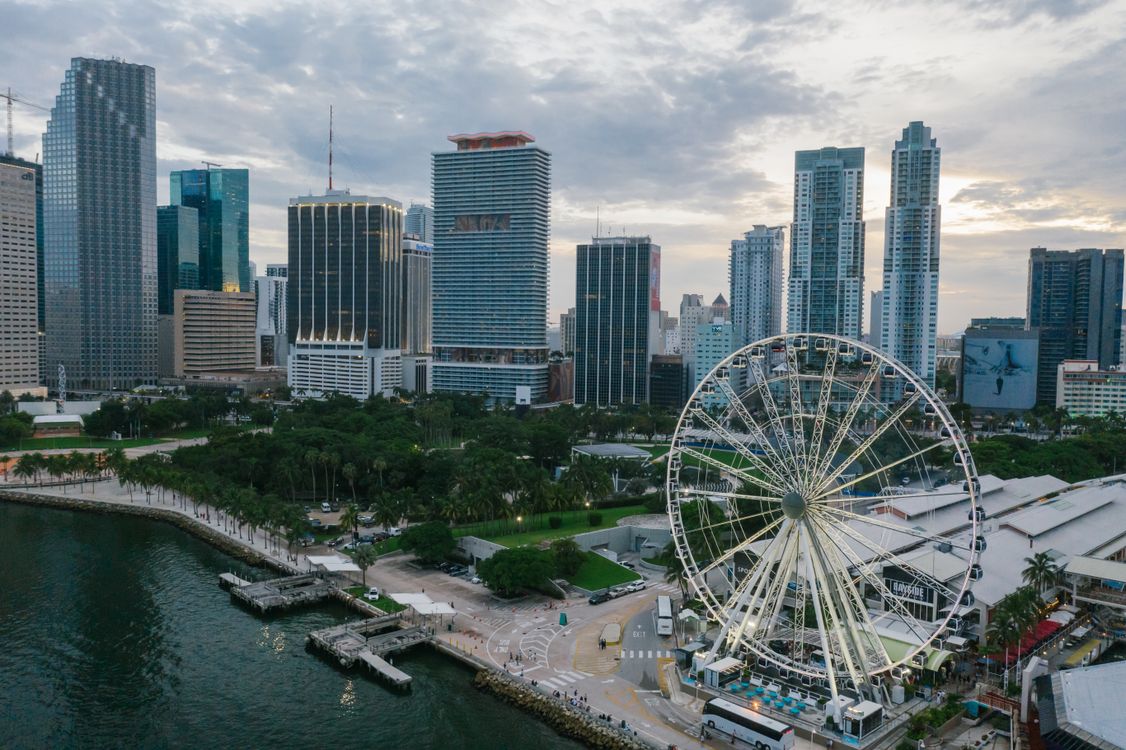 Aerial view of downtown Miami with the bayfront observation wheel, the urban core where Florida's no-state-income-tax structure continues drawing relocating buyers