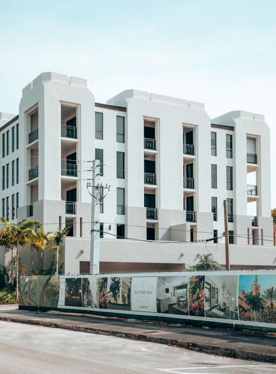 Condominio de lujo de Miami con valla de construcción y un cartel de ventas, el escenario de lanzamiento estancado que los compradores deben leer como palanca de negociación
