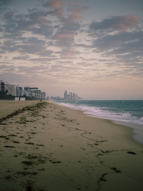 Playa frente al mar de Surfside al atardecer con torres de condominios de lujo a lo lejos, el mercado del sur de Florida donde el Delmore de DAMAC ha vendido cero unidades