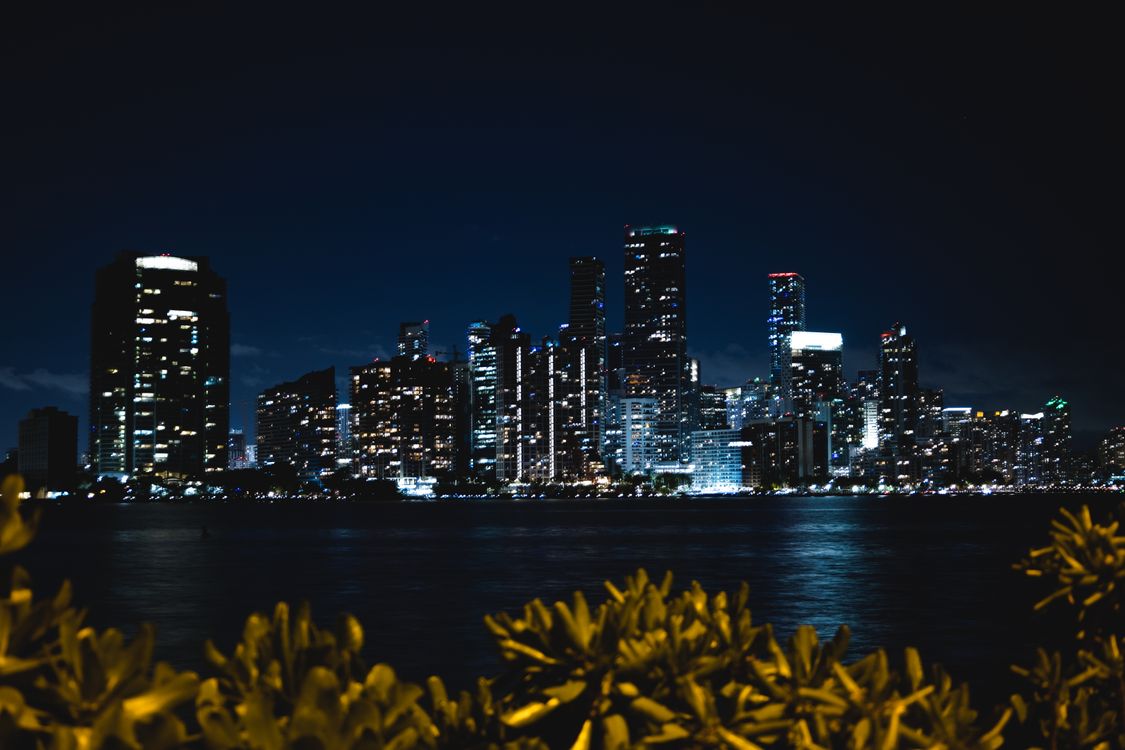 Horizonte del centro de Miami de noche brillando sobre Biscayne Bay, el mercado donde las ventas de viviendas de $1 millón o más subieron 14.7 por ciento en mayo de 2026