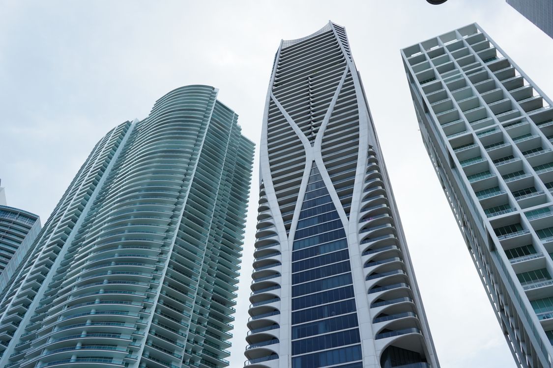 Torres de luxo de grande altura de Miami contra um ceu limpo, incluindo o One Thousand Museum, refletindo o ranking nacional #2 de Miami em crescimento de precos de luxo