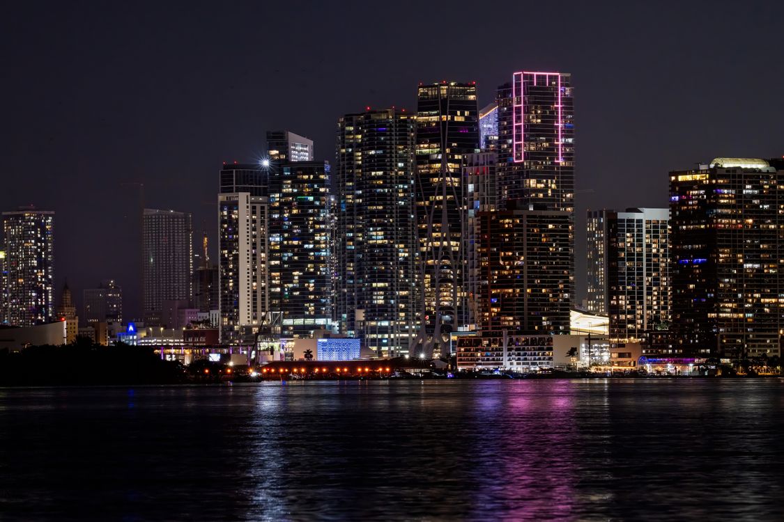 O horizonte de Miami visto através da Baía de Biscayne à noite, a partir dos bairros à beira-mar ao norte