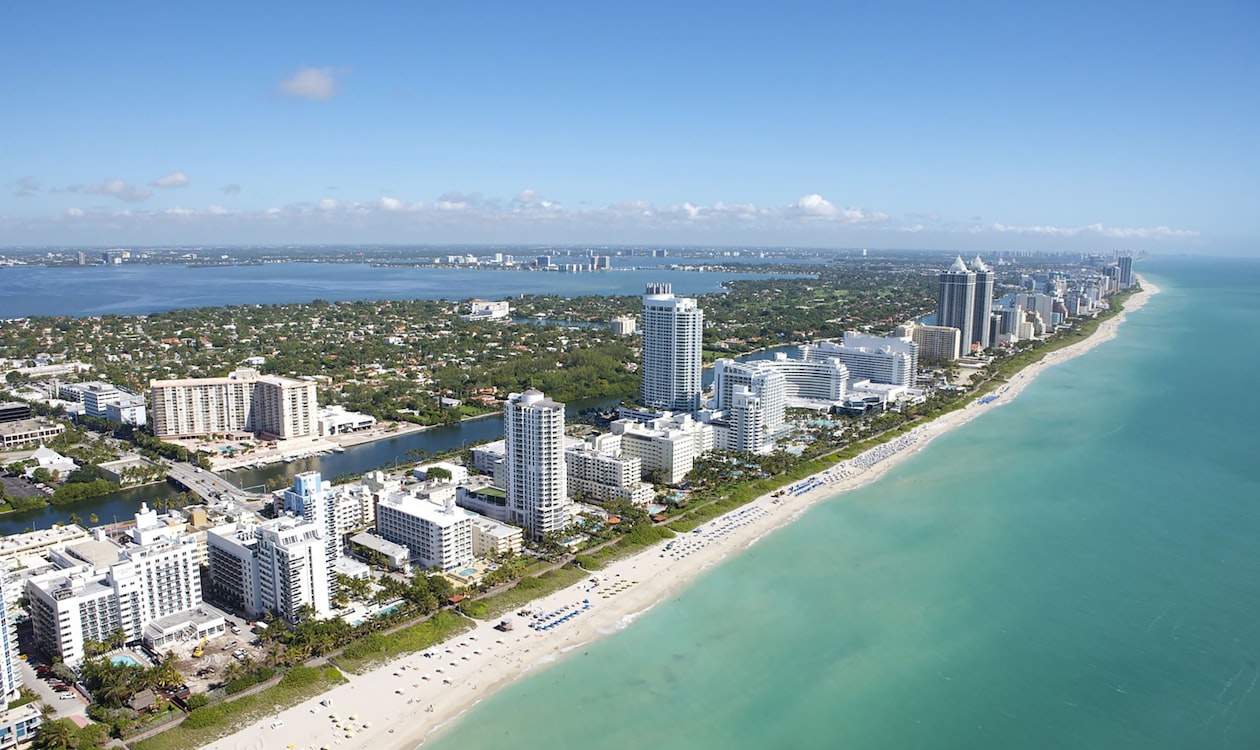 Vista aérea do corredor de condomínios à beira-mar em Miami Beach, onde se concentram os compradores de outros estados em 2026