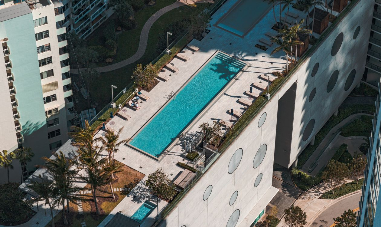 Vista aérea de una terraza de amenidades residenciales de lujo en Miami con piscina en azotea, similar al programa planeado en Fouquet's