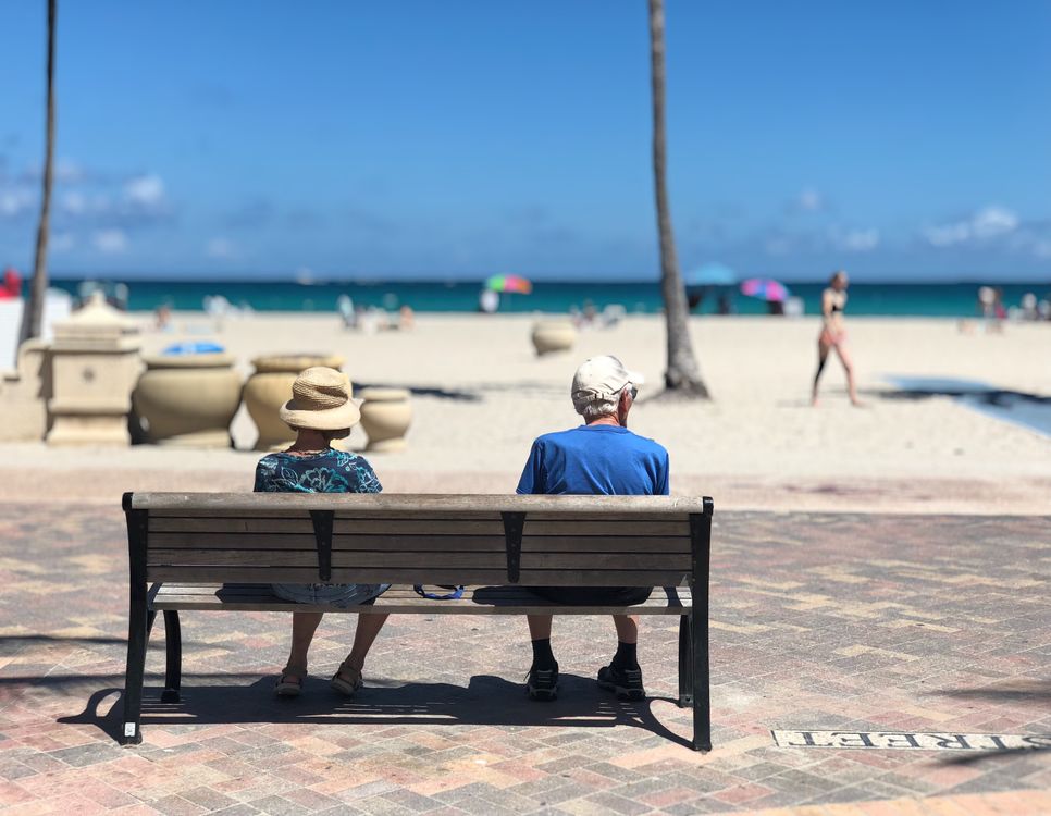 Pareja en un banco del paseo Broadwalk de Hollywood Beach frente al océano Atlántico