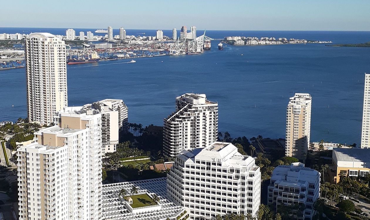 Torres de apartamentos à beira da Biscayne Bay em Brickell com o PortMiami e Fisher Island ao fundo