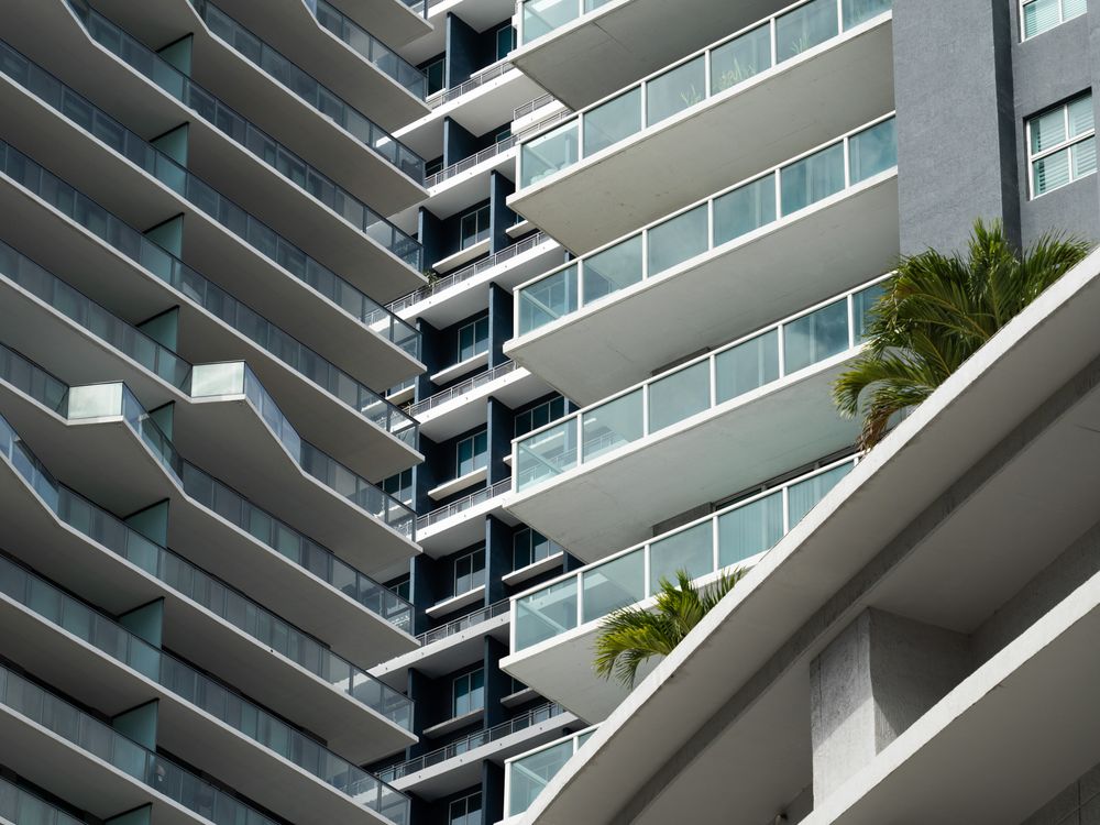 Vista cercana de dos torres de condominios en Miami con sus pilas de balcones llenando el encuadre, que representan las unidades financiadas por la estructura de capital de un proyecto