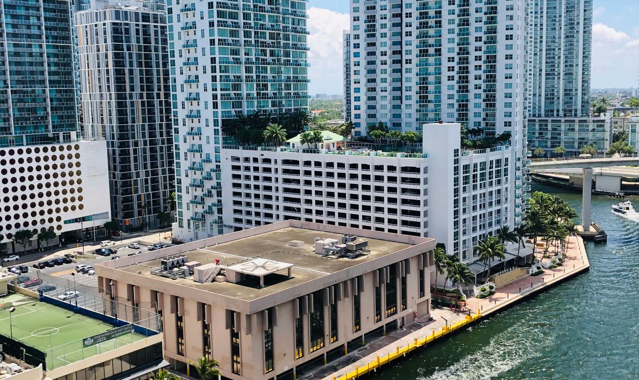 Vista aérea de torres de condominios frente al agua en Miami, la densidad de altura frente a la bahía que define el corredor de Edgewater y Biscayne
