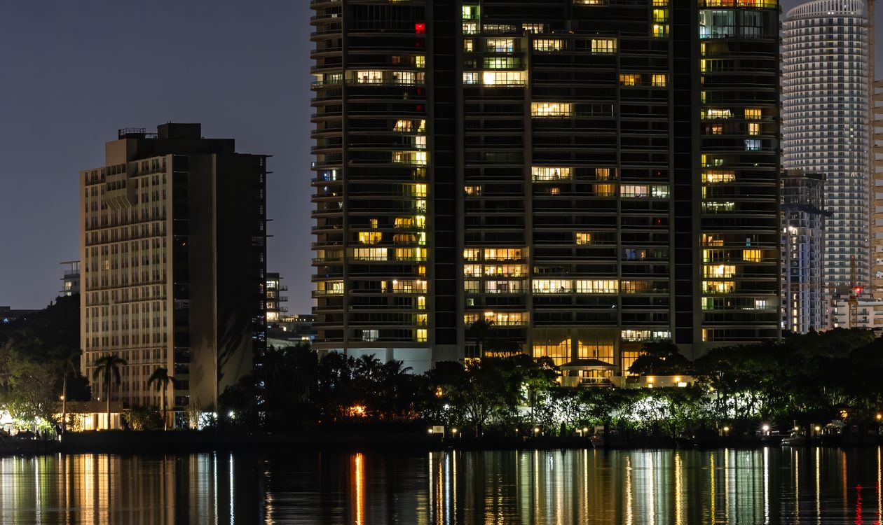 Miami waterfront condominium tower lit at night, the kind of established building now requiring a Full Review for conventional financing
