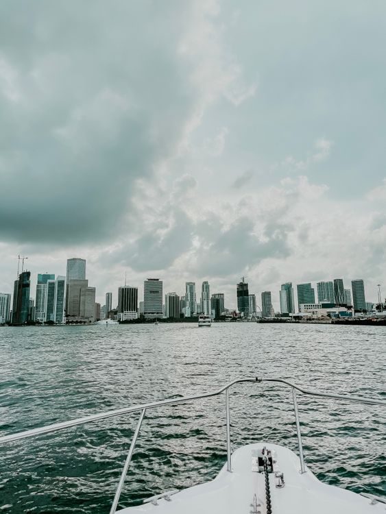 O horizonte do centro de Miami visto da Baía de Biscayne sob nuvens densas, com guindastes de construção visíveis