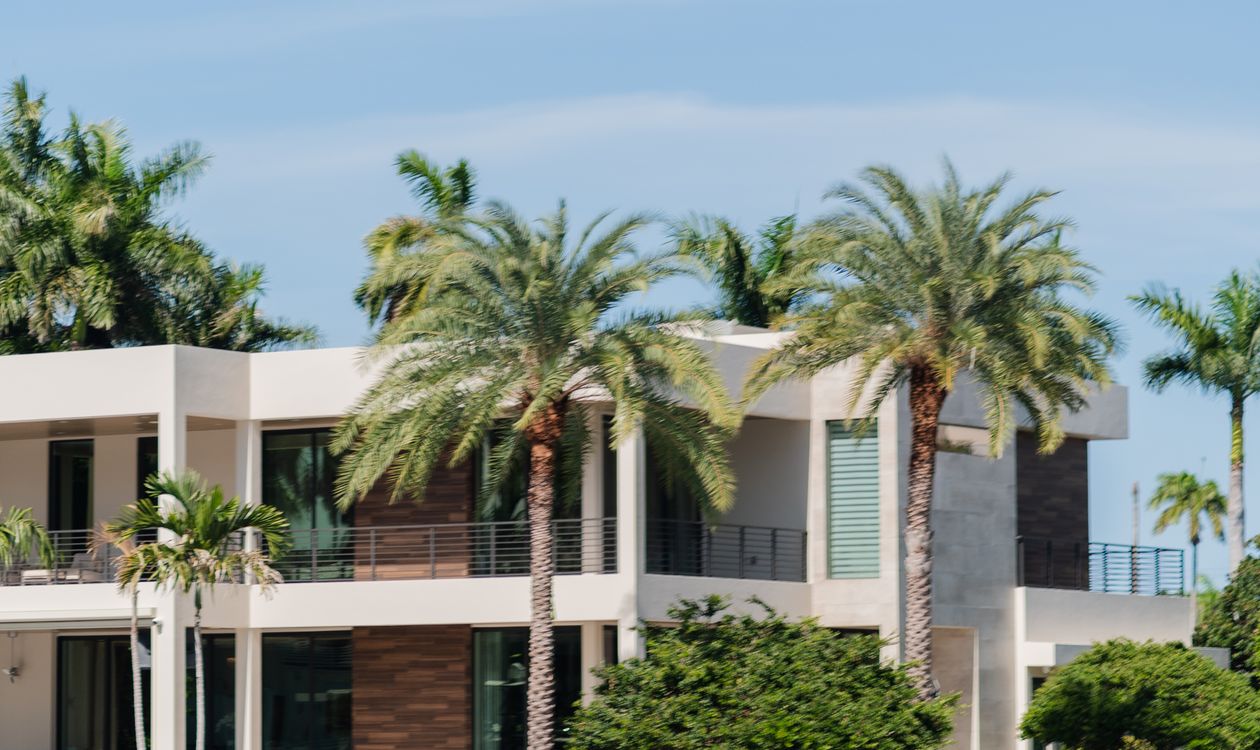 Casa unifamiliar moderna frente al agua con palmeras en Miami, el tipo de propiedad que sigue el índice de ventas repetidas Case-Shiller
