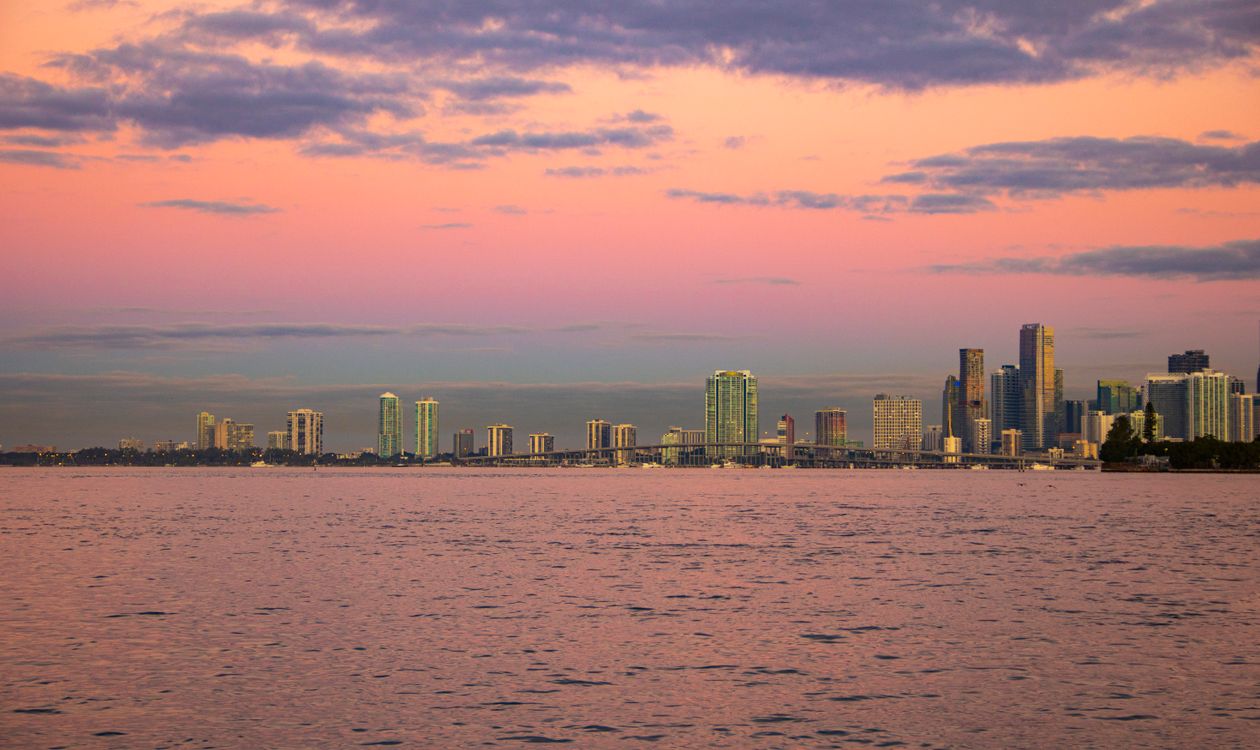El horizonte de Miami visto al atardecer sobre Biscayne Bay, con la calzada y las islas barrera bajas a lo lejos