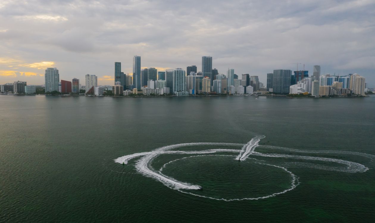El horizonte de Brickell y el centro de Miami visto sobre la bahía de Biscayne al atardecer con grúas de construcción en la costa