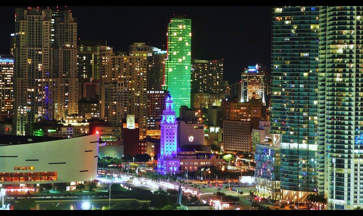 Downtown Miami condo towers lit at night seen from Biscayne Boulevard