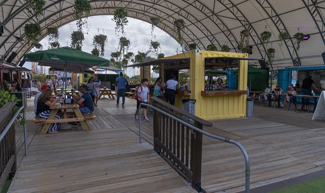 Open-air Wynwood Marketplace venue with shipping container bars and picnic tables in Miami