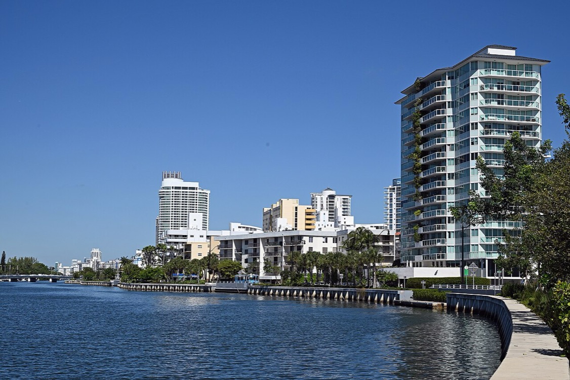 Glass condominium tower on the water along Indian Creek in Miami Beach, Florida