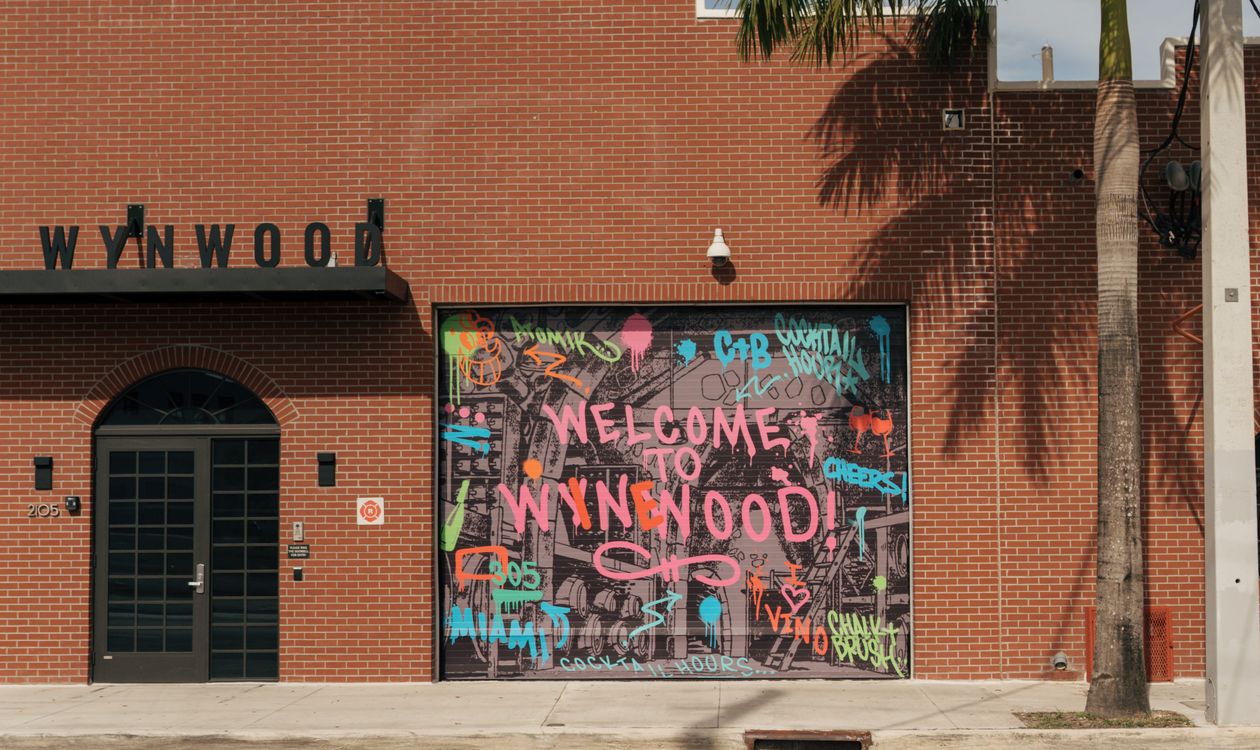 Welcome to Wynwood mural painted on a brick warehouse facade in the Wynwood arts district of Miami
