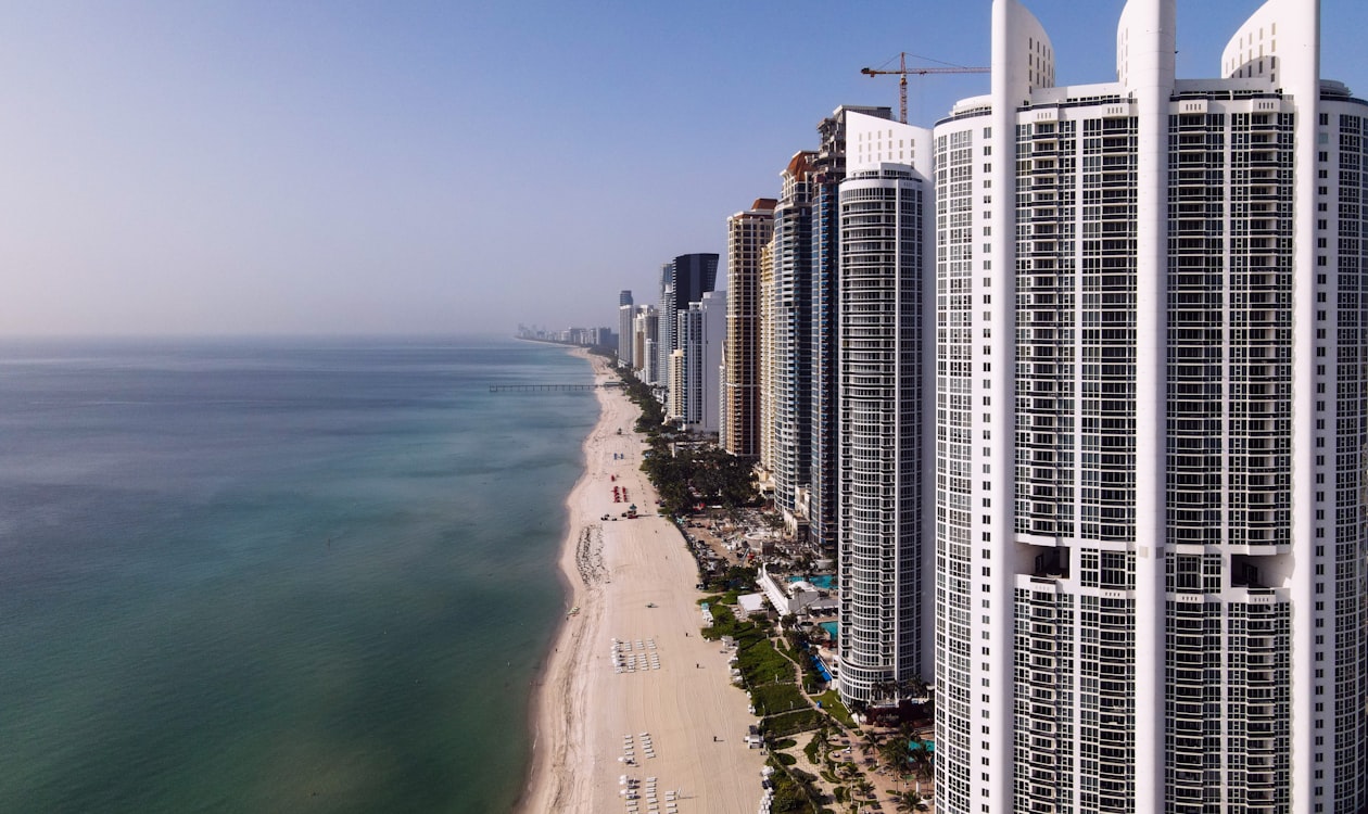 Aerial view of the Sunny Isles Beach oceanfront condominium towers lining the barrier island above the Atlantic