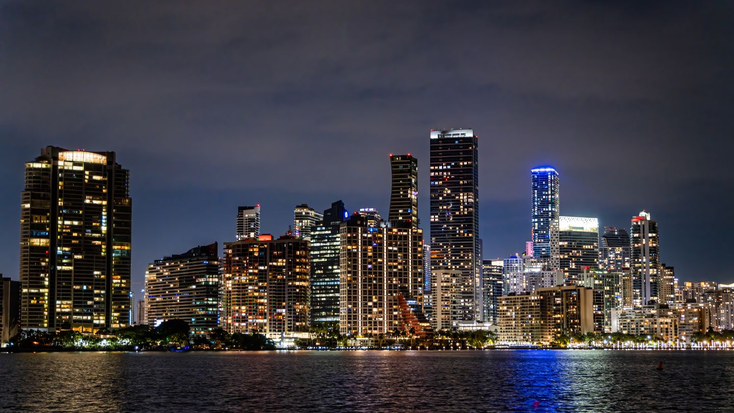 Melhores torres de condominios de luxo em pre-construcao de Miami iluminadas no horizonte de Brickell sobre a Baia de Biscayne a noite em 2026