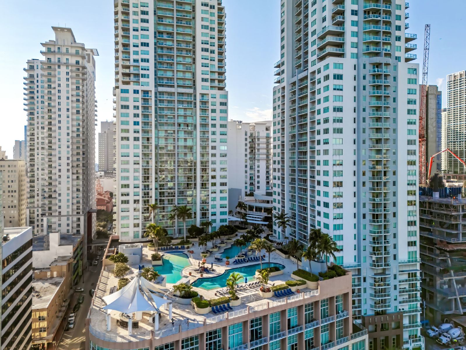 Brickell high-rise condominium pool deck seen from above with a new tower under construction alongside, Miami