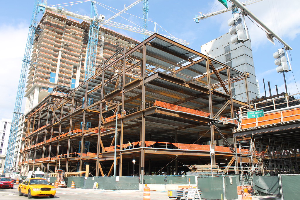 Miami condo tower under construction with tower cranes and exposed steel framing, the milestone stage where most assignment windows open