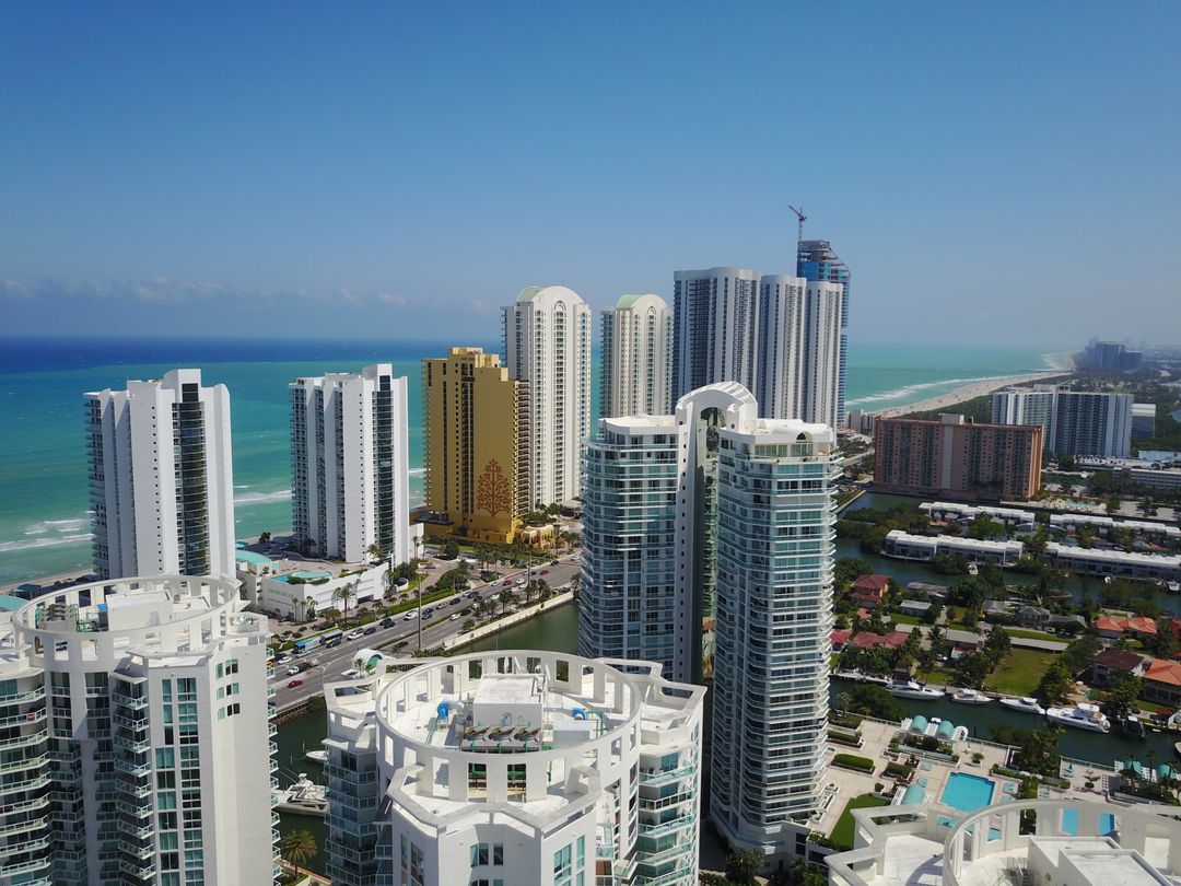 Torres frente al mar en Sunny Isles Beach con una grúa de construcción elevándose sobre Collins Avenue