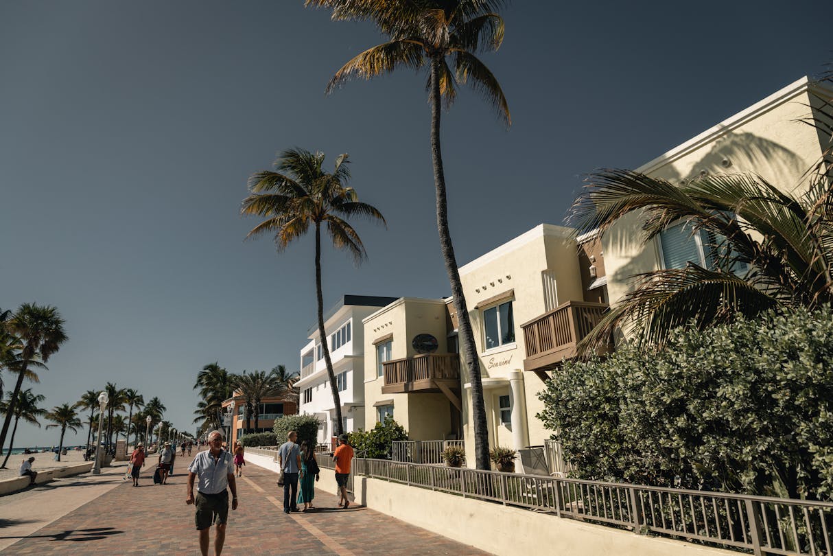 El Broadwalk de Hollywood Beach en Florida con palmeras y edificios de baja altura frente al mar a lo largo del paseo peatonal de 2,5 millas
