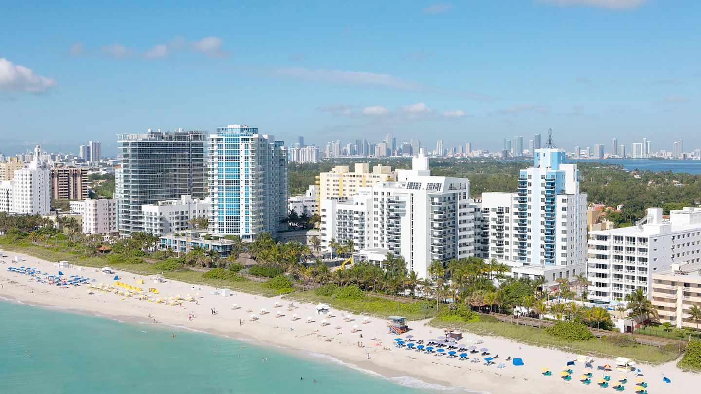Vista aérea de condomínios antigos à beira-mar de Miami Beach com o horizonte do centro, muitos já passados do gatilho de inspeção milestone