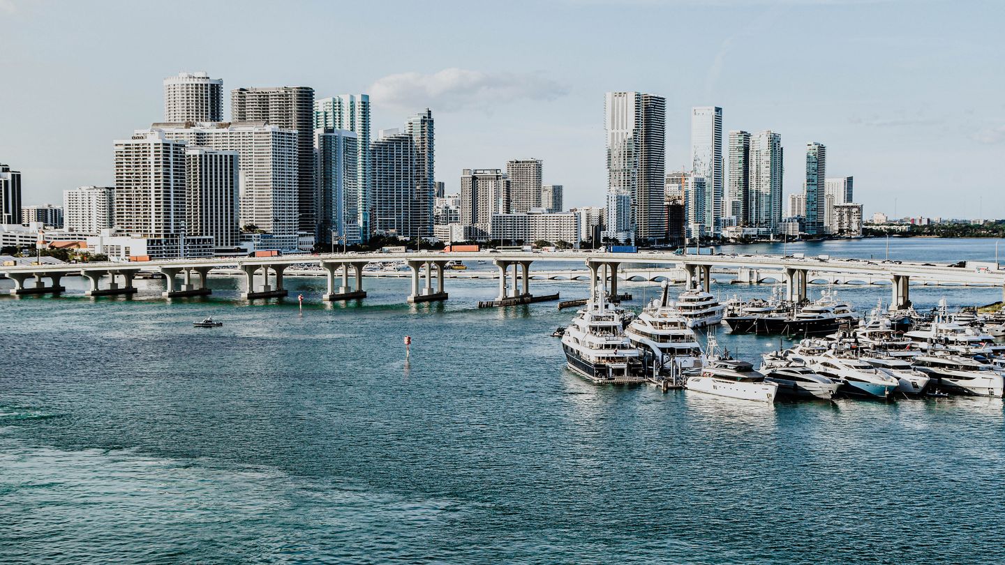 Horizonte a beira-mar de Miami com torres de condominios de luxo e uma marina de iates, o corredor de pre-construcao de Brickell e do centro em 2026