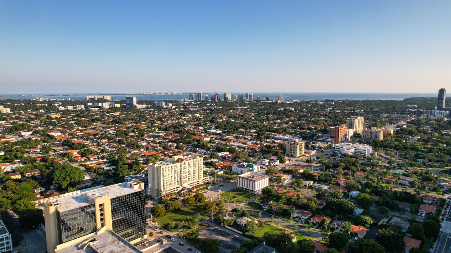 Vista aérea de zonas residenciales de Miami con torres de condominios en el horizonte de la bahía de Biscayne