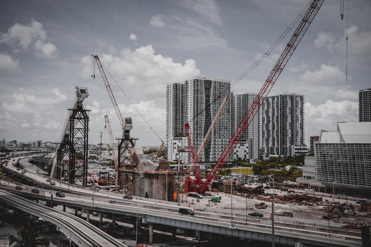 Grúas sobre una torre de condominios de Miami en construcción, donde los depósitos escalonados de preconstrucción financian cada fase del edificio