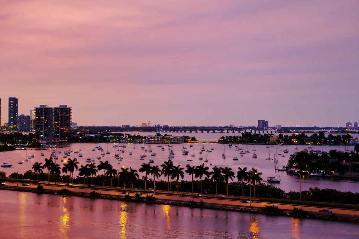 Biscayne Bay at dusk with Edgewater condominium towers and moored sailboats, the Miami waterfront corridor where preconstruction closings concentrate
