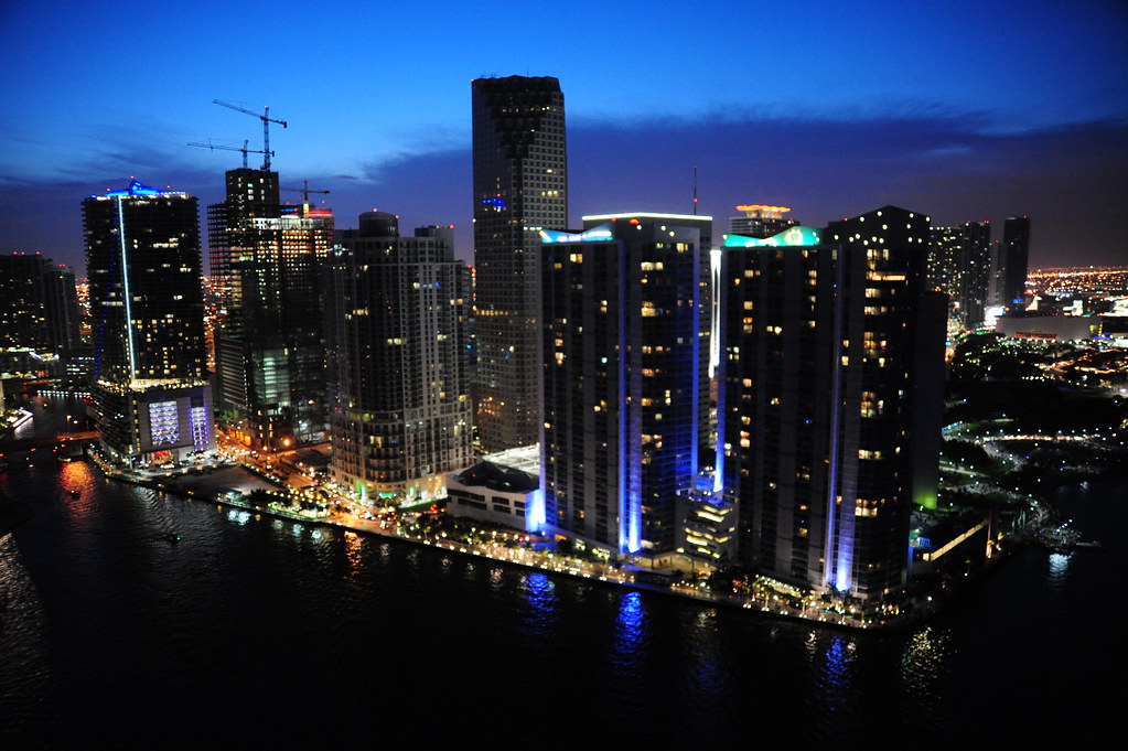 Miami River mouth at night with condo towers under construction and lit cranes, the pre-delivery window when assignments trade