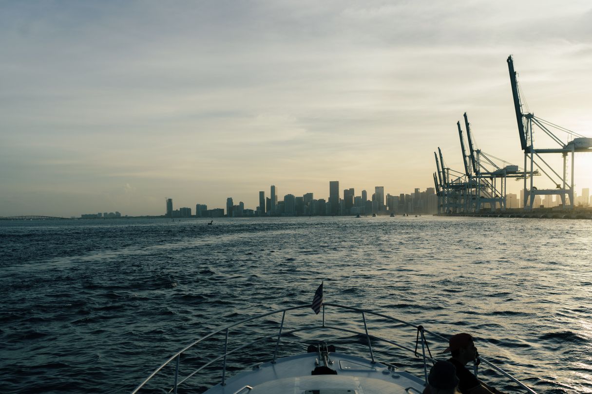 The Downtown Miami and Brickell skyline seen from the water with the Port of Miami gantry cranes on the right