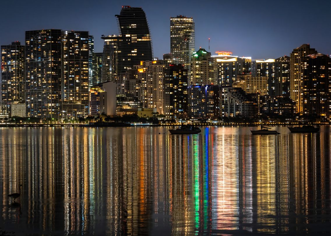 Torres de condominios de lujo de Brickell reflejadas sobre la bahía de Biscayne de noche en Miami