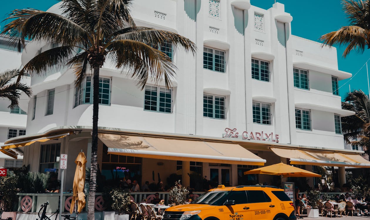 South Beach Miami Ocean Drive with iconic Art Deco Carlyle Hotel, palm trees, and blue sky