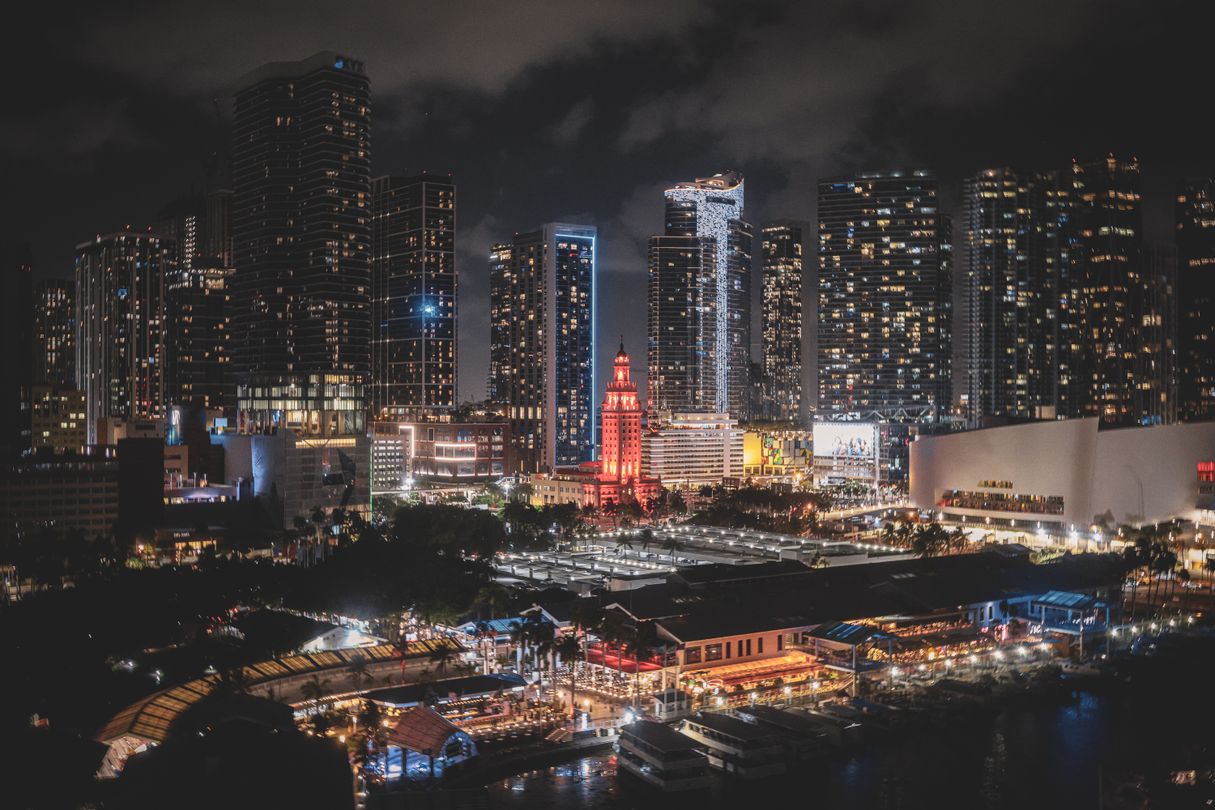 Downtown Miami at night with the Freedom Tower and the Park West tower cluster, home to the Waldorf Astoria, Delano and E11EVEN branded projects