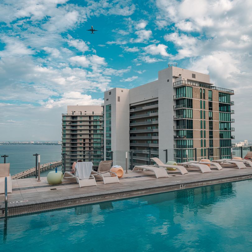 Rooftop pool deck on a Miami condominium overlooking Biscayne Bay, the amenity layer a branded operator is contracted to run