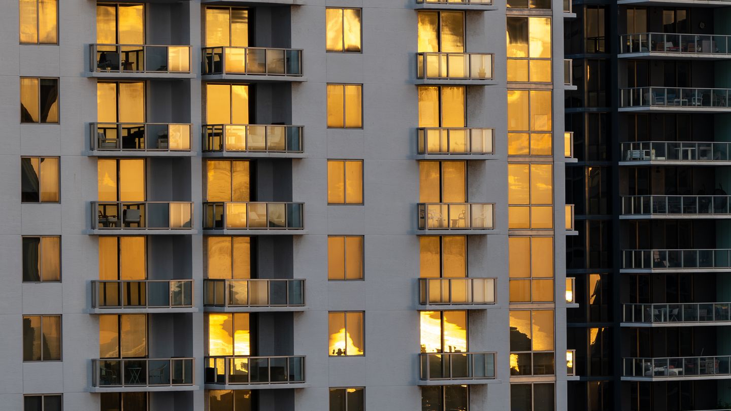 A Miami condominium unit stack lit by low sunset light, balcony by balcony