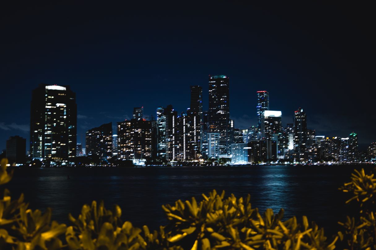 Torres de condominios en construcción de Miami-Dade y el skyline de noche sobre Biscayne Bay, cartera de preconstrucción 2026