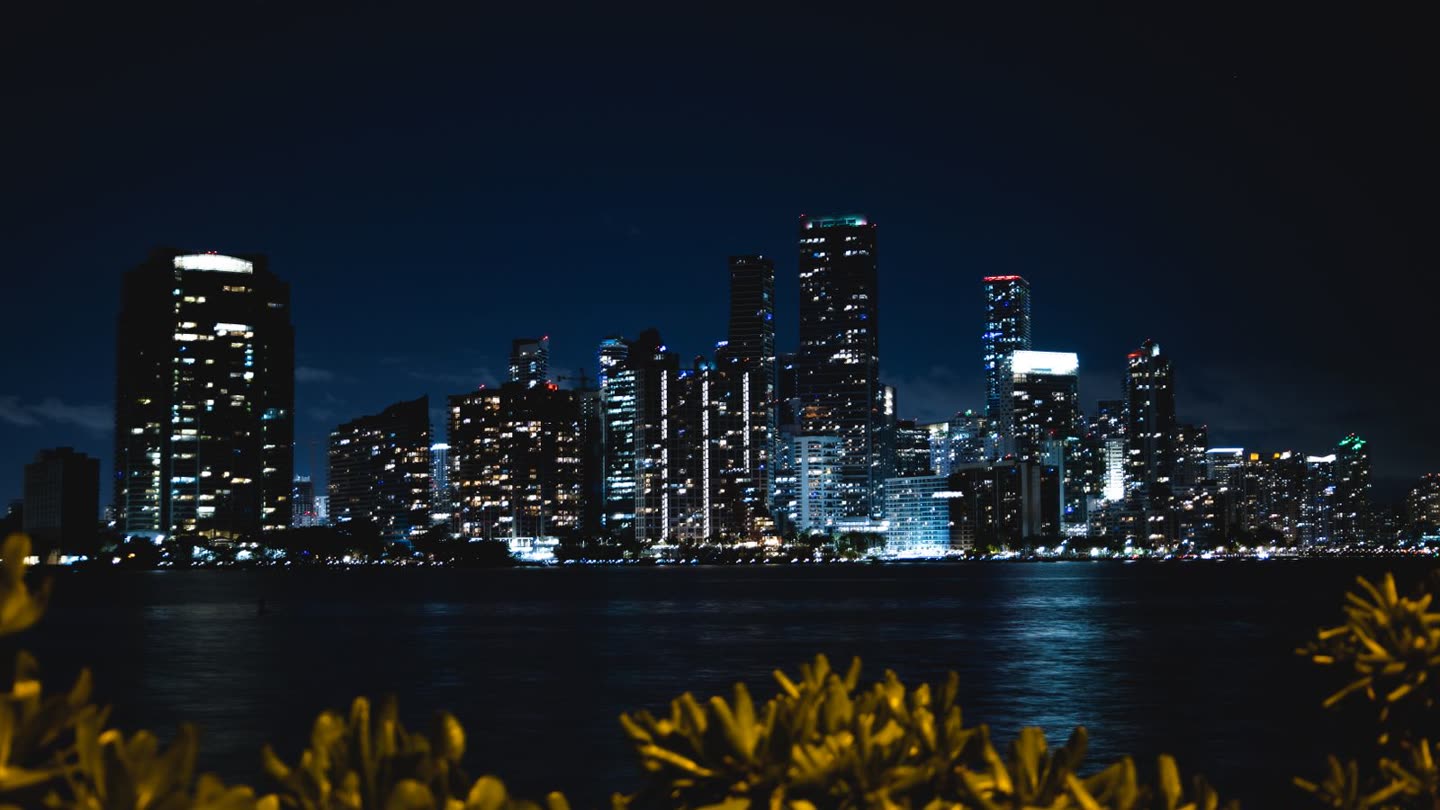 Brickell tower wall lit at night across Biscayne Bay, led by the 827-foot Panorama Tower