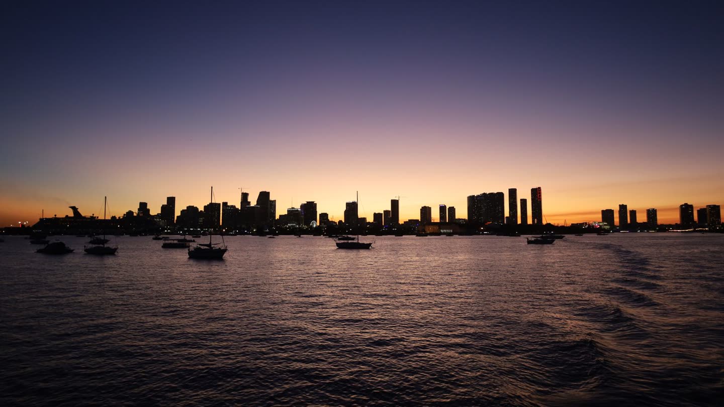 Miami skyline silhouette at twilight with construction cranes marking the next generation of towers