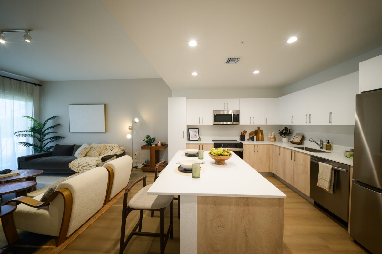 Cozinha e sala de um apartamento do Upland Park com marcenaria italiana e bancadas de quartzo